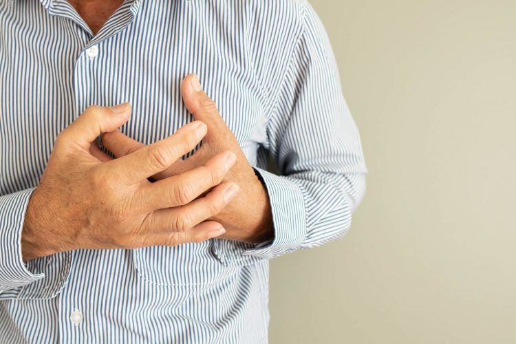 Heart attack problems. Senior man suffering from severe chest pain. Warning signs of unstable angina or myocardrial infarction disease. Health care and cardiological concept. Close up. Copy space.